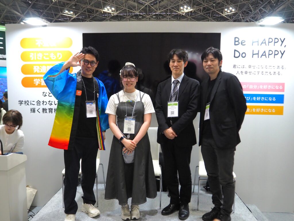 EDIX2026のNIJINブースで、生徒と校長・大学教授が並ぶ様子