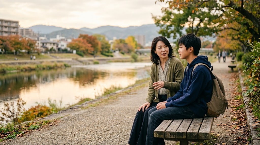 川沿いの公園のベンチで、母親と高校生の息子が並んで座って話している